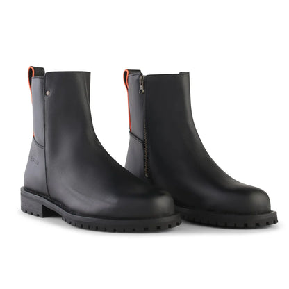 Women’s Meti steel toe work boots in Raven black full-grain leather with side zipper, slip resistant outsole, and high visibility orange pull tab side view